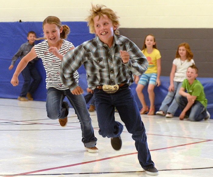 (Al Hartmann | The Salt Lake Tribune) Twins Molly and Makarty Larsen hit the ground running in a game of "Red Rover" in the gym during morning recess for 3rd-5th graders at Park Valley School.