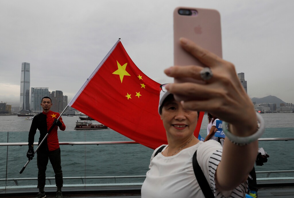 (Vincent Yu | AP Photo) In this Saturday, Aug. 17, 2019 file photo, pro-China supporters take a selfie with a Chinese national flag to support police and anti-violence during a rally at a park in Hong Kong. Twitter said Monday it has suspended more than 200,000 accounts that it believes were part of a Chinese government influence campaign targeting the protest movement in Hong Kong.
