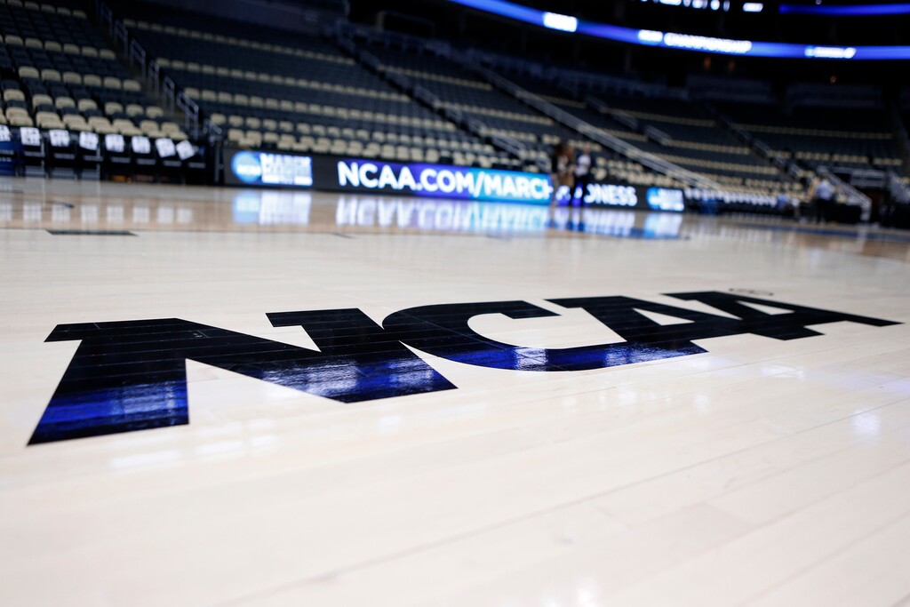 FILE - In this Wednesday, March 18, 2015 file photo, The NCAA logo is on the court as work continues at The Consol Energy Center in Pittsburgh. Imagine an NCAA Tournament with no fans in the arenas. What normally would be thought an impossibility isn't so far-fetched as the United States and the rest of the world attempt to contain the spread of the new coronavirus.  (AP Photo/Keith Srakocic, File)