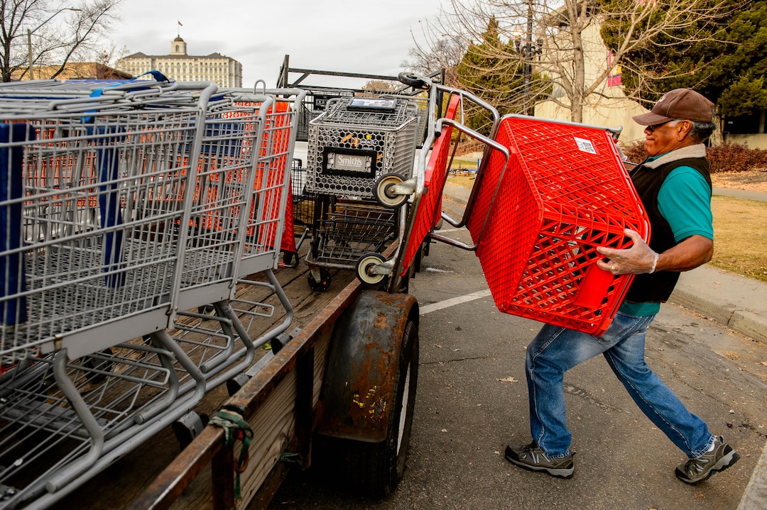 (Trent Nelson  |  The Salt Lake Tribune) Antonio Hernandez loads a shopping cart reclaimed near the Salt Lake City Library on Tuesday, Nov. 19, 2019. Hernandez, an employee of Romac, is assigned to drive around the city and pick up stolen or abandoned shopping carts for return to stores.