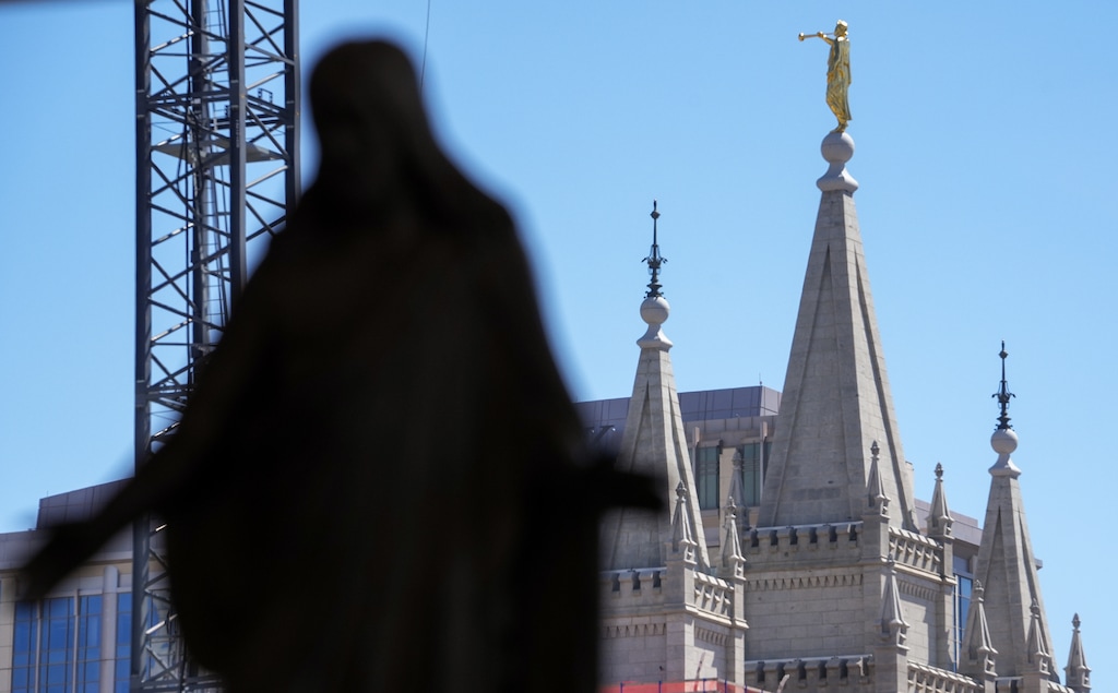 (Chris Samuels | The Salt Lake Tribune) The Salt Lake Temple is seen past a statue of Jesus Christ at the Conference Center in Salt Lake City, Sunday, April 6, 2025. The church announced 15 new temples Sunday.