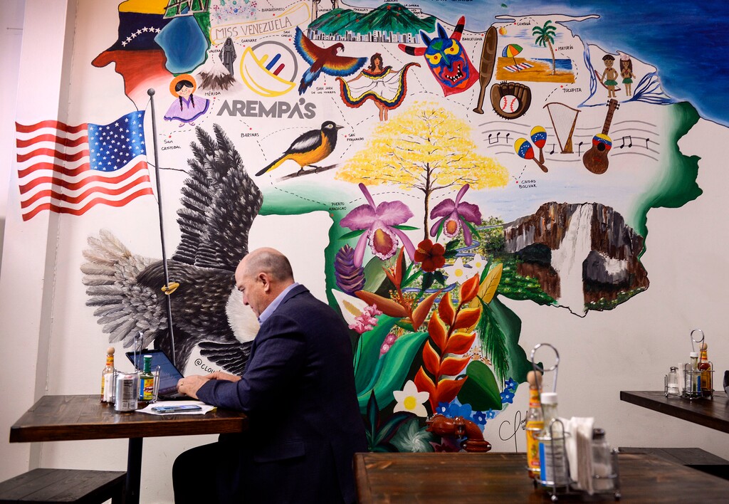 (Leah Hogsten  |  The Salt Lake Tribune)  Carl Black finishes his working lunch on his computer at Arempa's Venezuelan Cuisine, a new Venezuelan restaurant in downtown SLC on Thursday. The mural of Venezuela was painted by the hostess and cashier, Claudia Estaba. 