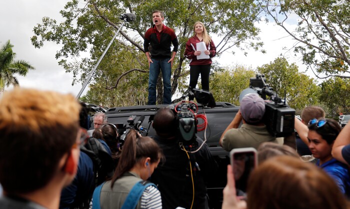 Organizers Cameron Kasky, left, and Jackie Corin, student survivors from Marjory Stoneman Douglas High School address fellow students before boarding buses in Parkland, Fla., Tuesday, Feb. 20, 2018, to rally outside the state capitol.   The students plan to hold a rally Wednesday in hopes that it will put pressure on the state's Republican-controlled Legislature to consider a sweeping package of gun-control laws, something some GOP lawmakers said Monday they would consider. (AP Photo/Gerald Herbert)