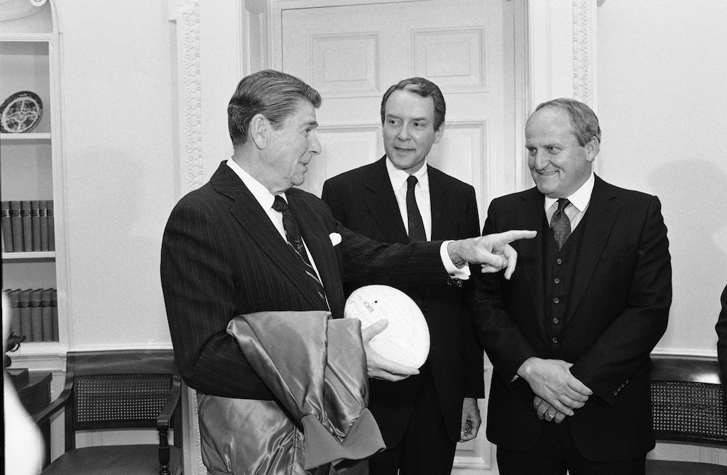 (Ira Schwarz | AP) President Ronald Reagan is presented a jacket and autographed football from the coach of the National Champion college football team in the nation, LaVell Edwards, head coach of the Brigham Young University Cougars. With them is Sen. Orrin Hatch, R-Utah, center on Jan. 14, 1985, in Washington.
