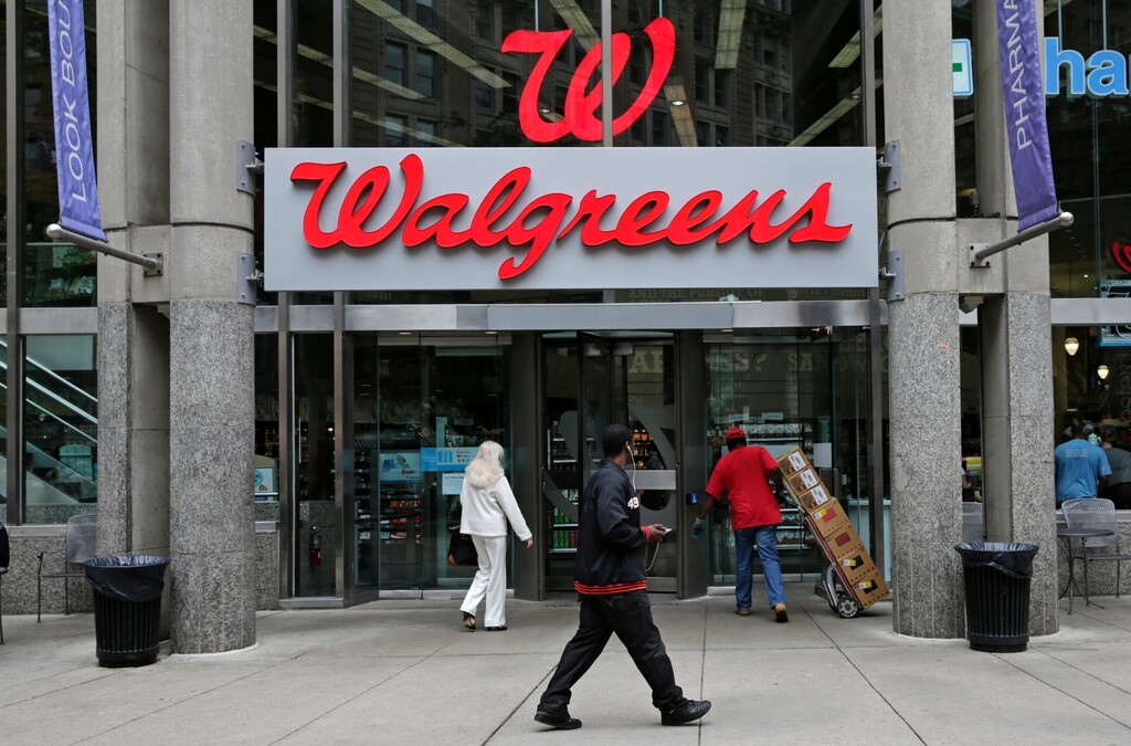 (Charles Krupa | The Associated Press) In this June 4, 2014, file photo, people walk in to a Walgreens retail store in Boston. Walgreens gave investors a better-than-expected third quarter, raised its dividend and detailed a big share buyback Thursday, June 28, 2018. But shares of the nation’s largest drugstore chain and its competitors tanked after Amazon.com took another step into their territory by announcing the purchase of PillPack, a relatively new online pharmacy that offers pre-sorted prescription dose packaging and home delivery.
