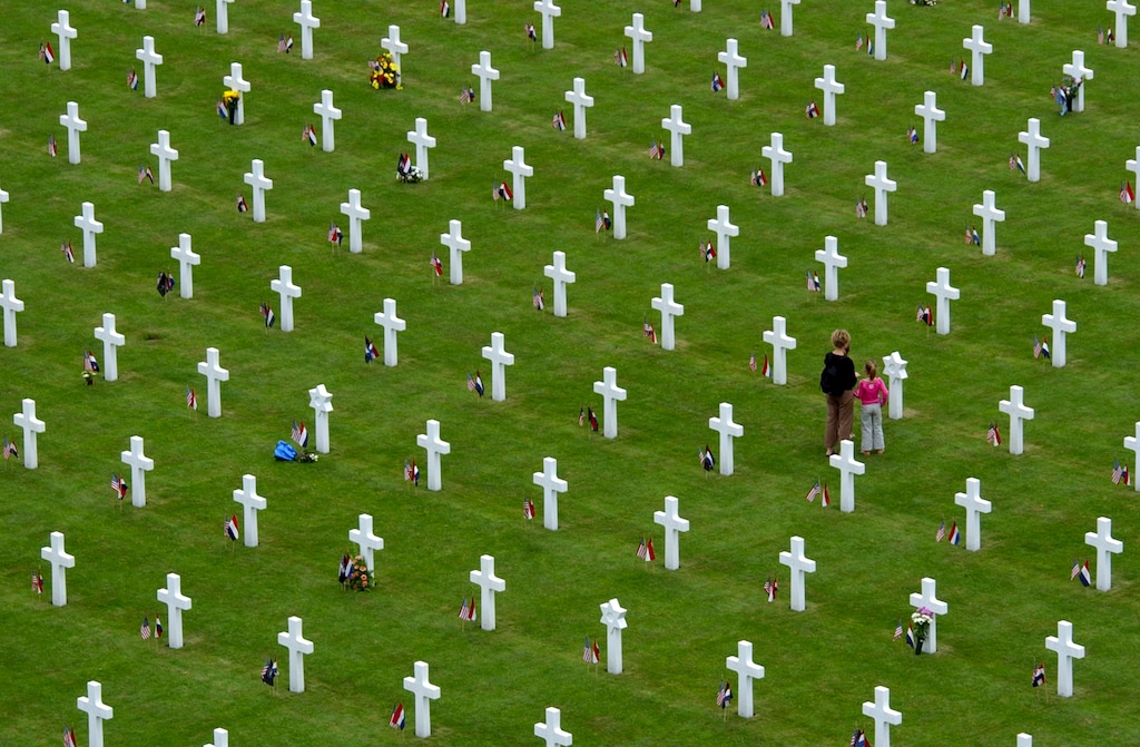 (Peter Dejong | AP file photo)
In this May 30, 2004, image, people pause at a grave with the Star of David amidst other graves as they attend the 60-year commemoration service ahead of Memorial Day at the Netherlands American Cemetery in Margraten, southern Netherlands. A total of 8,302 war veterans and war victims are buried at the cemetery. With the help of volunteers in the Netherlands, Belgium and the United States scouring newspaper archives and other sources, the Faces of Margraten project of Dutch historian Sebastiaan Vonk has so far uncovered photos of more than 7,500 of the U.S servicemen and women buried or commemorated at Margraten. They were due to be displayed next to graves in Margraten this week as Europe commemorates the 75th anniversary of the end of World War II, but the event was cancelled due to COVID-19 coronavirus related measures.