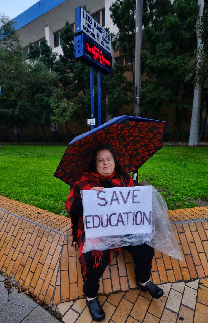 (Richard Vogel | The Associated Press)  Barbara Jacobs, a teacher at Los Angeles High School, sits in the rain during a city-wide teacher strike at Los Angeles High School on Monday, Jan. 14, 2019. Tens of thousands of Los Angeles teachers went on strike Monday after contentious contract negotiations failed in the nation's second-largest school district.
