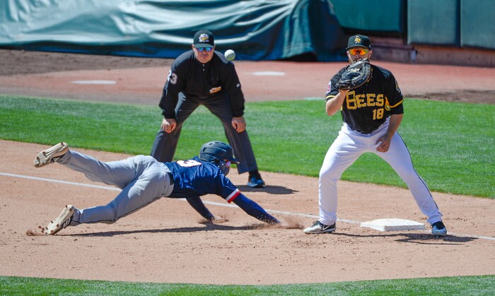 (Francisco Kjolseth  |  The Salt Lake Tribune)  J.P. Crawford of the Rainiers safely slides back into first past Jared Walsh of the Bees during their game at Smtih's Ballpark in Salt  Lake City on Thursday, May 2, 2019.