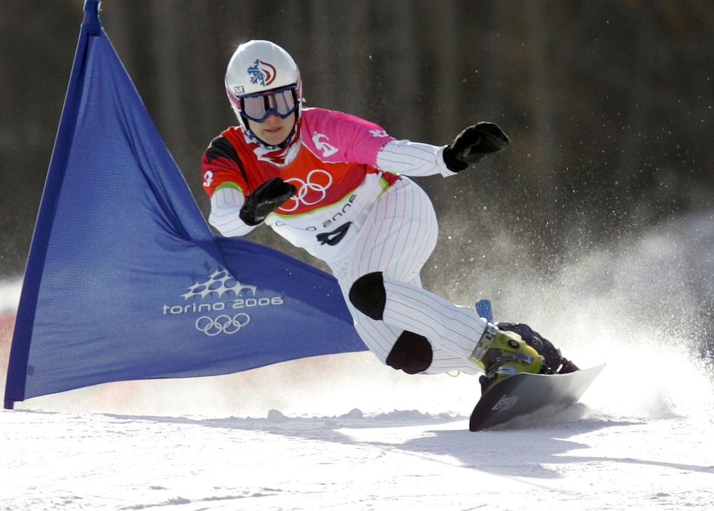 (Charles Krupa | AP) United States athlete Rosey Fletcher clears a gate during the women's snowboard parallel giant slalom race at the Turin 2006 Winter Olympic Games in Bardonecchia, Italy, on Feb. 23, 2006. Olympic bronze medalist Rosey Fletcher filed a lawsuit accusing former snowboard coach Peter Foley of sexually assaulting, harassing and intimidating members of his team for years, while the organizations overseeing the team did nothing to stop it. Fletcher is a plaintiff in one of two lawsuits filed in U.S. District Court in Los Angeles on Thursday, Feb. 2, 2023.