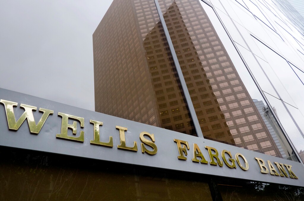 (Richard Vogel | The Associated Press) In this May 5, 2015 file photo, a downtown building is reflected in the windows of a Wells Fargo Bank in Los Angeles. Wells Fargo reports quarterly financial results Wednesday, Oct. 14, 2015.