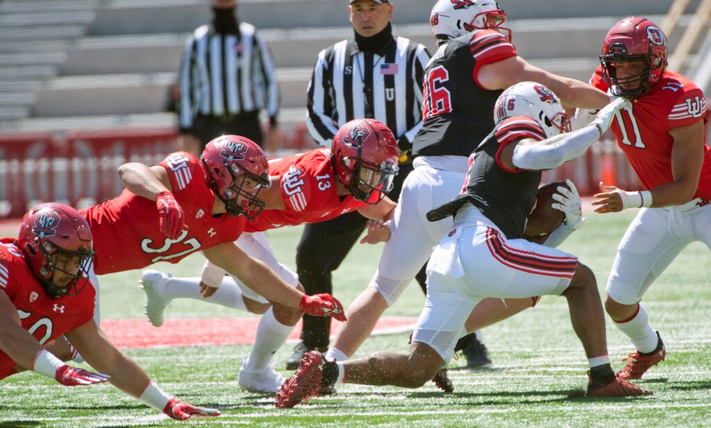 (Ed Kosmicki | Special to The Tribune) The red team defensemen close in on black team running back T J Pledger during the annual spring football game at the University of Utah, 17 April 2021.