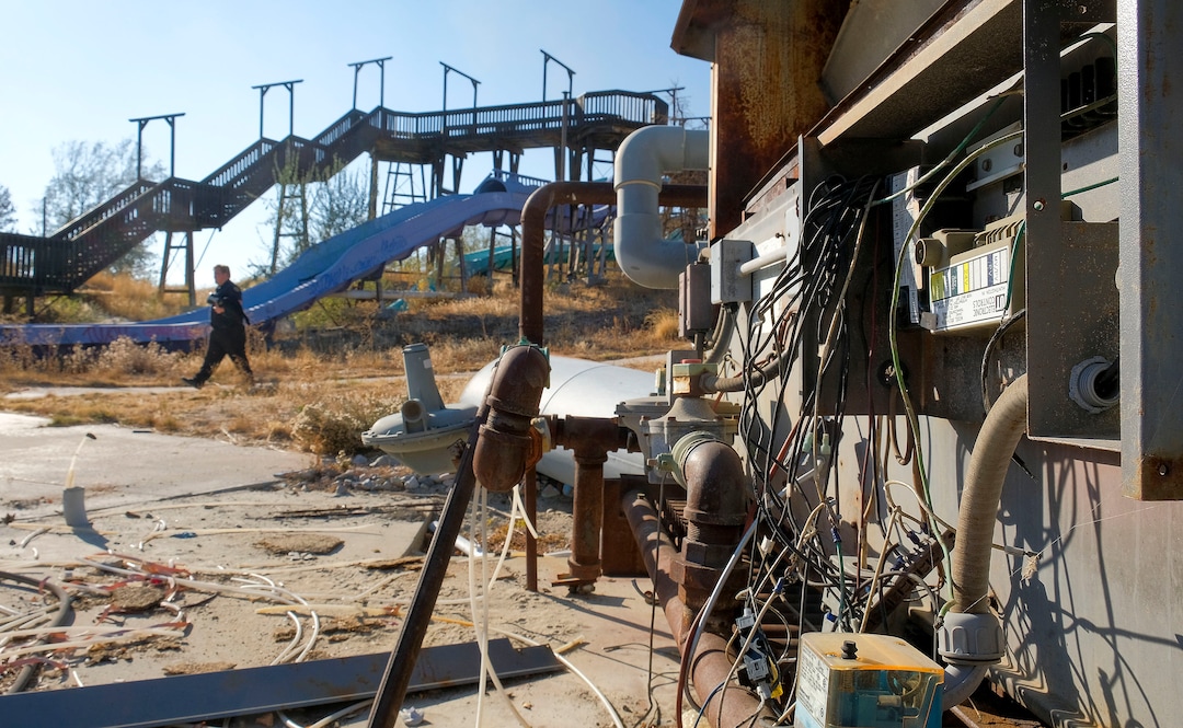 (Leah Hogsten  |  The Salt Lake Tribune) Security guard Nathan Lancaster walks the property, Oct. 29, 2020. In the 1980's Raging Waters water park was home to the world's third wave pool. Today the property is in such disrepair that Salt Lake City needs to disassemble it and figure out some kind of new park to replace it. Closed since 2018,vandalism and operator abandonment has left the park a liability for the city.