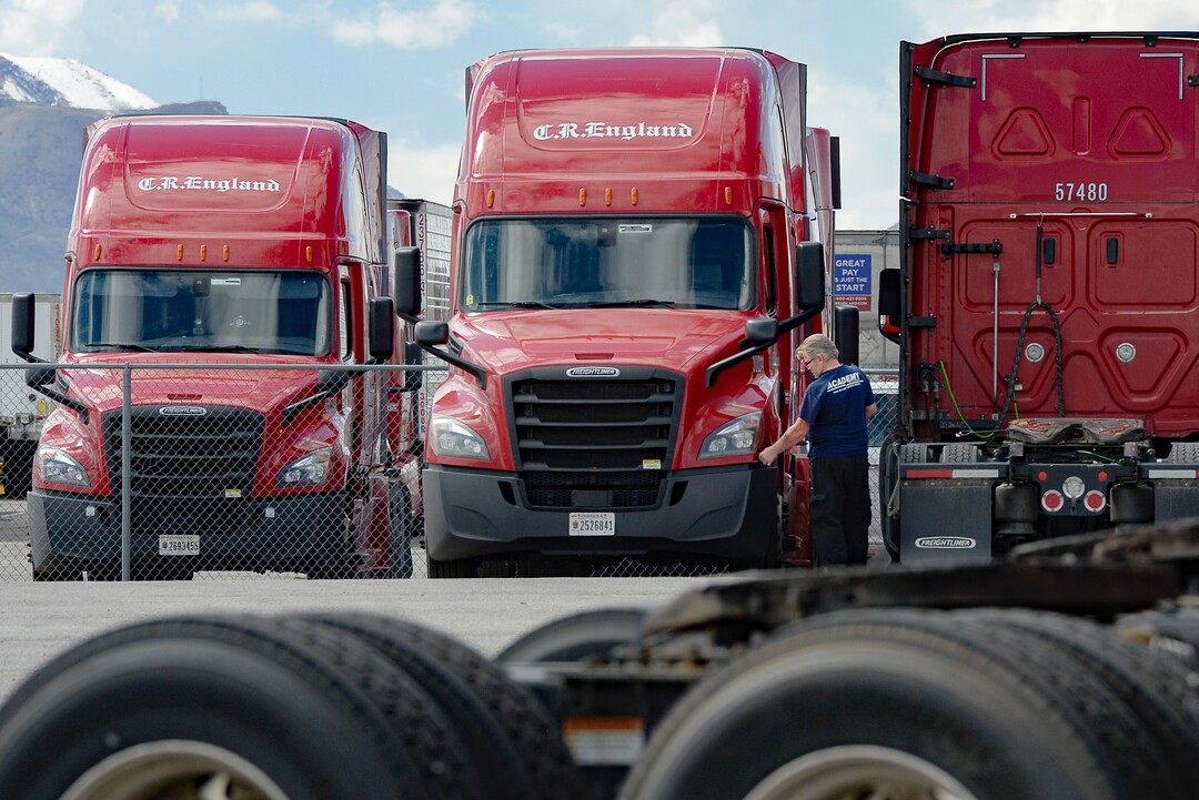 (Francisco Kjolseth  |  The Salt Lake Tribune) A driver inspects his rig as trucks come and go at C.R. England trucking in Salt Lake City on Monday, March 30, 2020. The coronavirus outbreak has helped make truckers heroes as they help to stock empty shelves in stores. Drivers face new challenges from finding restrooms and food on the road amid shutdowns, but say they enjoy driving with no congestion.