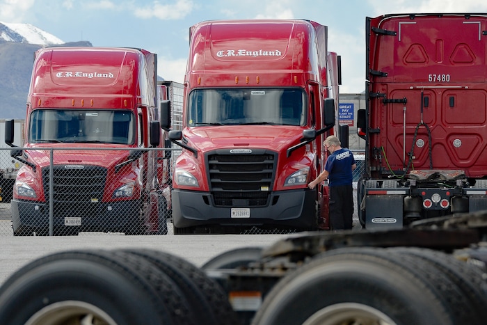 (Francisco Kjolseth | The Salt Lake Tribune) A driver inspects his rig as trucks come and go at C.R. England trucking in Salt Lake City on Monday, March 30, 2020. The coronavirus outbreak has helped make truckers heroes as they help to stock empty shelves in stores. Drivers face new challenges from finding restrooms and food on the road amid shutdowns, but say they enjoy driving with no congestion.