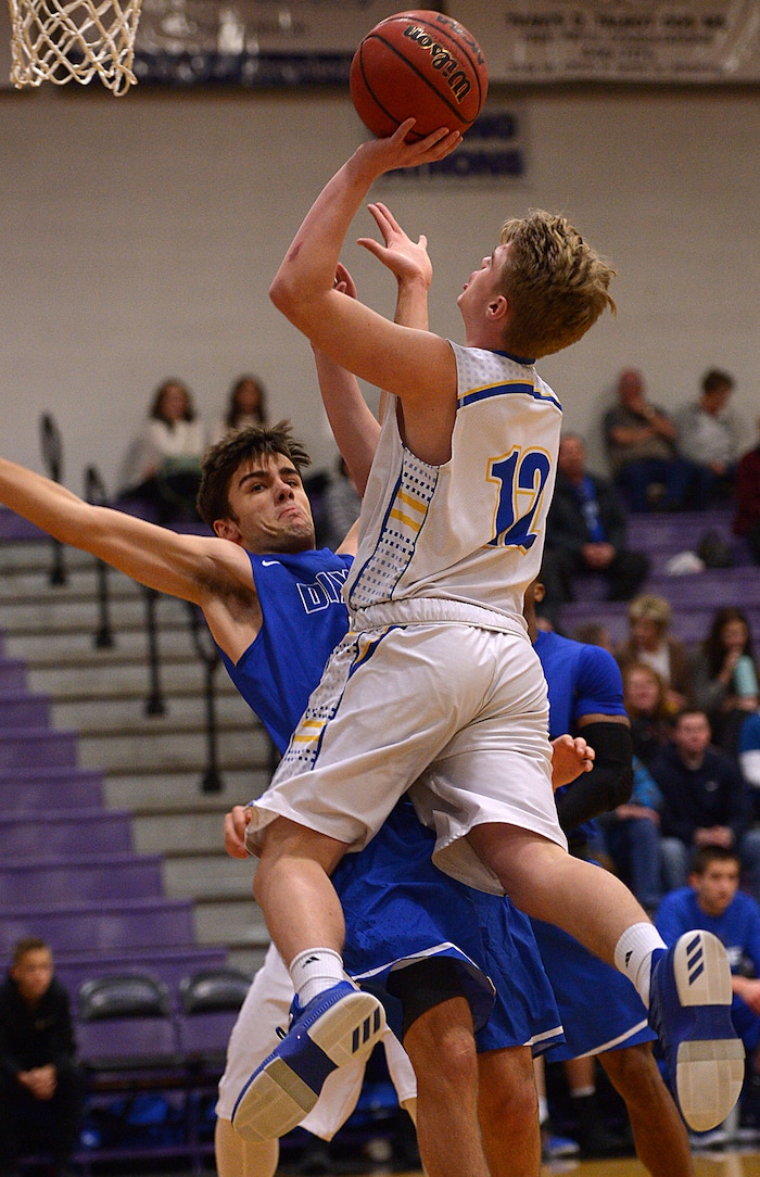 (Leah Hogsten  |  The Salt Lake Tribune) Cyprus' Logan Hendrickson hits the net around Dixie's Jace Bennett.  Dixie High School defeated Cyprus High School boys' basketball team 59-52 during the Riverton Holiday Tournament in Riverton, December 28, 2017. 