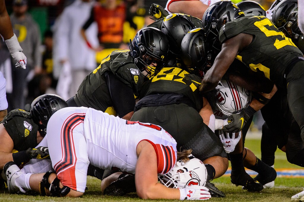 (Trent Nelson  |  The Salt Lake Tribune) Utah running back Zack Moss (2) is stopped by Oregon defenders in the Pac-12 football championship game in Santa Clara, Calif.