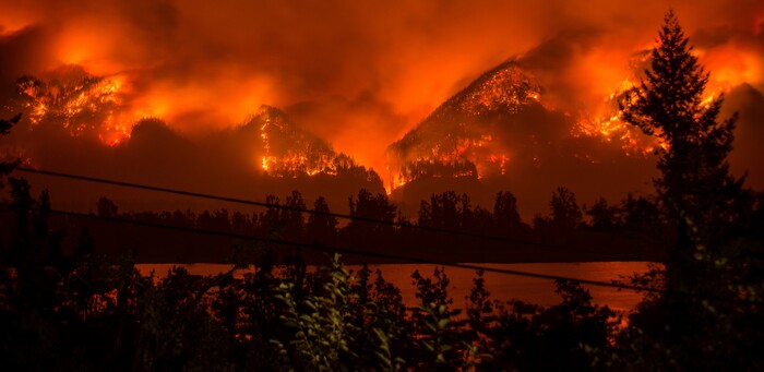 FILE--This Monday, Sept. 4, 2017, file photo provided by KATU-TV shows a wildfire as seen from near Stevenson Wash., across the Columbia River, burning in the Columbia River Gorge above Cascade Locks, Ore. The fast-moving wildfire chewing through Oregon's Columbia River Gorge is threatening more than homes and people. It's also devouring the heart of the state's nature-loving identity. (Tristan Fortsch/KATU-TV via AP, file)