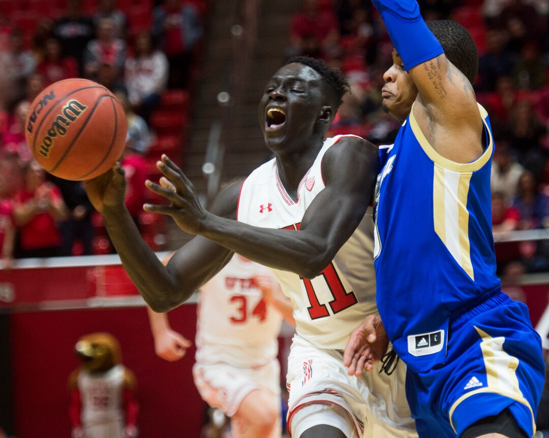 (Rick Egan  |  The Salt Lake Tribune)        Utah Utes forward Both Gach (11) grimaces as he collides with Tulsa Golden Hurricane guard Elijah Joiner (3), in basketball action between, Utah Utes and Tulsa Golden Hurricane, at the Jon M. Huntsman Center, Saturday, Dec. 1, 2018.