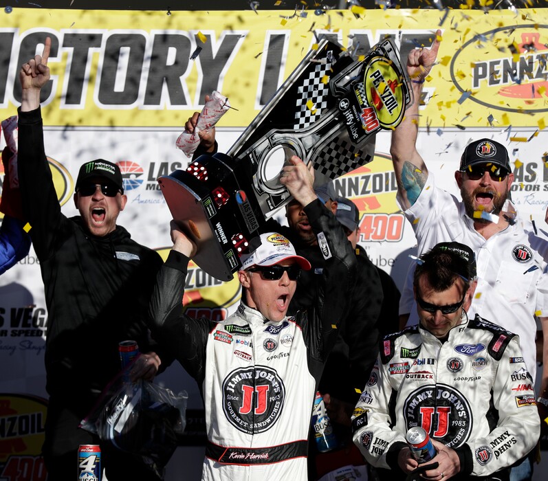 Kevin Harvick hoists the trophy with his team after winning a NASCAR Cup series auto race Sunday, March 4, 2018, in Las Vegas. (AP Photo/Isaac Brekken)