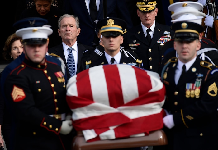 Former President George W. Bush and former first lady Laura Bush, left, watch as the casket of former President George H.W. Bush is carried after a State Funeral at the National Cathedral in Washington, Wednesday, Dec. 5, 2018.(AP Photo/Susan Walsh)