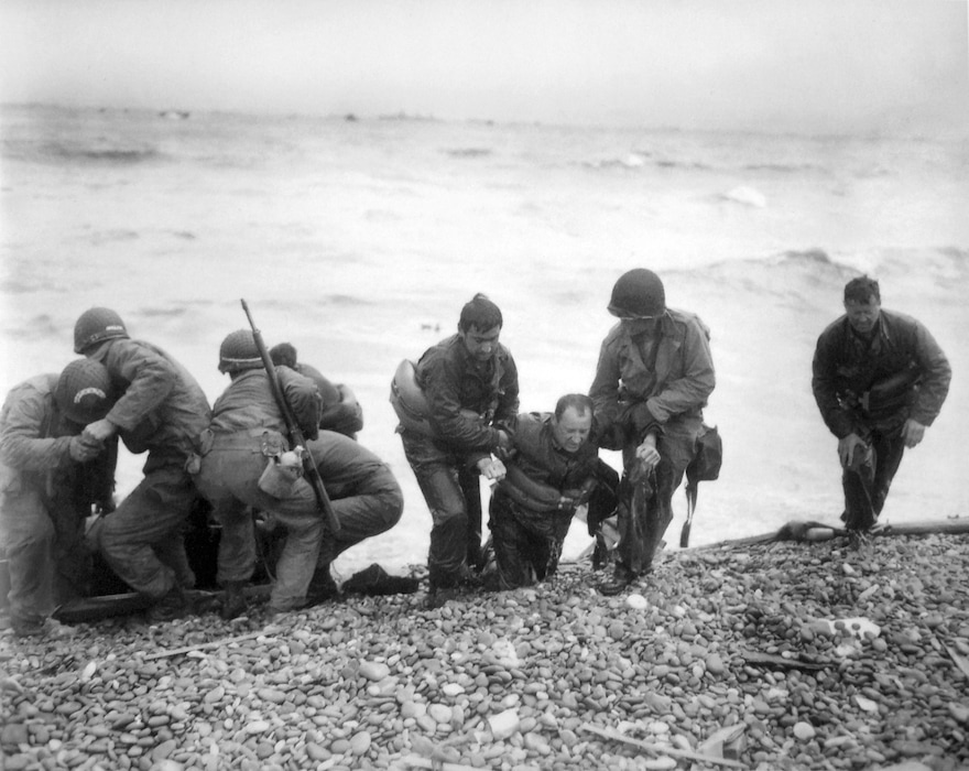 (Louis Weintraub | AP) Members of an American landing unit help their comrades ashore Utah Beach during the Normandy invasion, June 6, 1944.