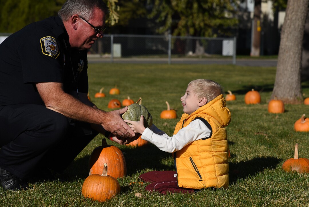 (Francisco Kjolseth  |  The Salt Lake Tribune)  Noah Wright, 9, gets a little help picking out a pumpkin from Jim Hudspeth, with the department of corrections as students at Jordan Valley School in Midvale, Canyon District's school for students with severe disabilities, get a chance to pick out a pumpkin from their very own pumpkin patch set up in front of the school on Wed. Oct. 24, 2018. Inmates who take part in the Green Thumb Nursery program at the Utah State prison grew and harvested the pumpkins that were donated to the school for the 10th year.