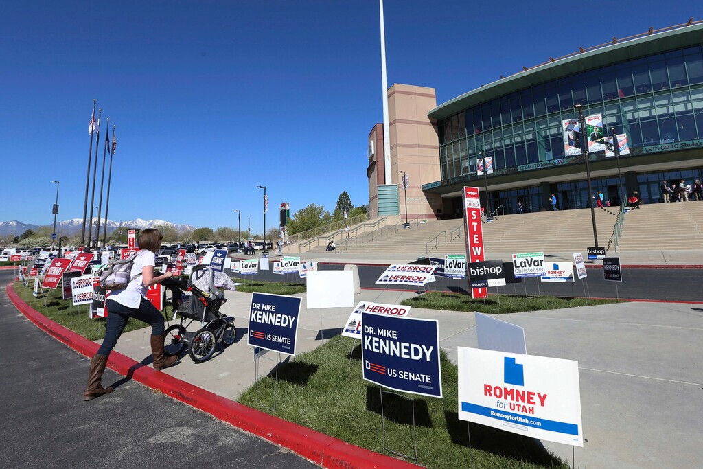 A woman and her baby head to the Maverick Center to attend the Utah Republican 2018 nominating convention Saturday, April 21, 2018, in West Valley City, Utah. Mitt Romney is facing nearly a dozen Republican contenders in Utah on Saturday as he works to secure the state GOP nomination for a Senate seat without a primary. (AP Photo/George Frey)