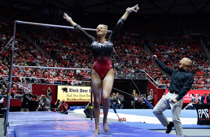 (Francisco Kjolseth  |  The Salt Lake Tribune)  Makenna Merrell-Giles is cheered by co-head coach Tom Farden after sticking her landing on the bars as Utah hosts Penn State in their season opener at the Huntsman Center in Salt Lake City on Saturday, Jan. 5, 2019.
