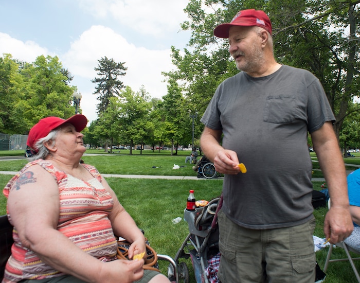 (Rick Egan  |  The Salt Lake Tribune)      
Sugar House residents, Janice and Derek Mullins, talk about how they met three years ago this weekend, when they were both homeless. They returned to Pioneer park to visit friends, as the Salt Lake City Mission fed and donated clothes to the homeless in Pioneer Park on Memorial day, Monday, May 28, 2018.


