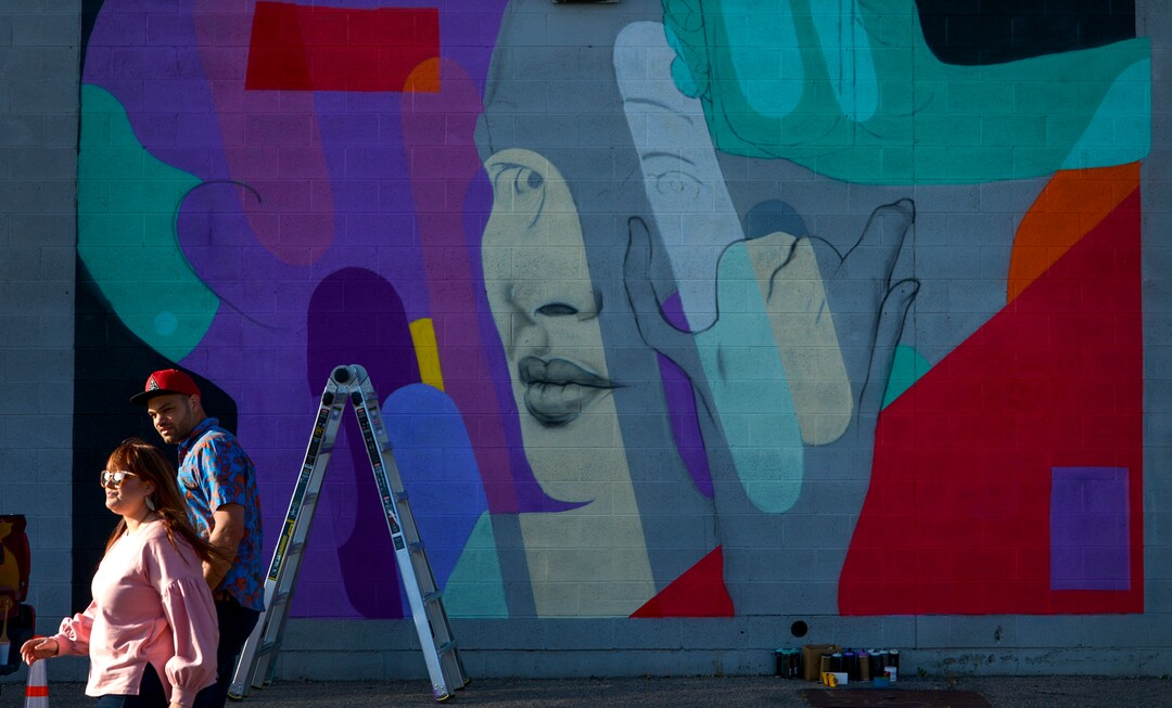 (Leah Hogsten | The Salt Lake Tribune) People pass by Chuck Landvatter's mural on the wall fo Shades Brewing at Utopia Ave. during the 2nd annual Mural Fest sponsored by South Salt Lake Arts Council and Utah Arts Alliance. Ten murals were created in South Salt Lake's community between 2100 and 2400 South off of West Temple, May 11, 2019.