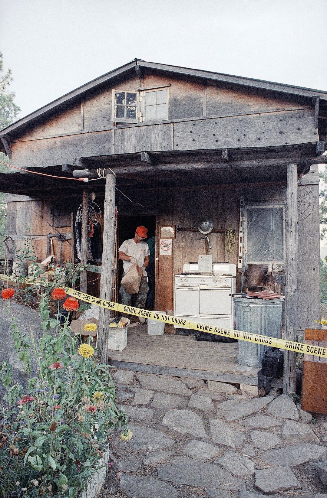 FILE - In this Aug. 31, 1992, file photo, federal agents gather evidence from the home of captured fugitive Randy Weaver near Naples, Idaho. It's been a quarter century since a standoff in the remote mountains of northern Idaho left a 14-year-old boy, his mother and a federal agent dead and sparked the expansion of radical right-wing groups across the country that continues to this day. (AP Photo/Gary Stewart, File)