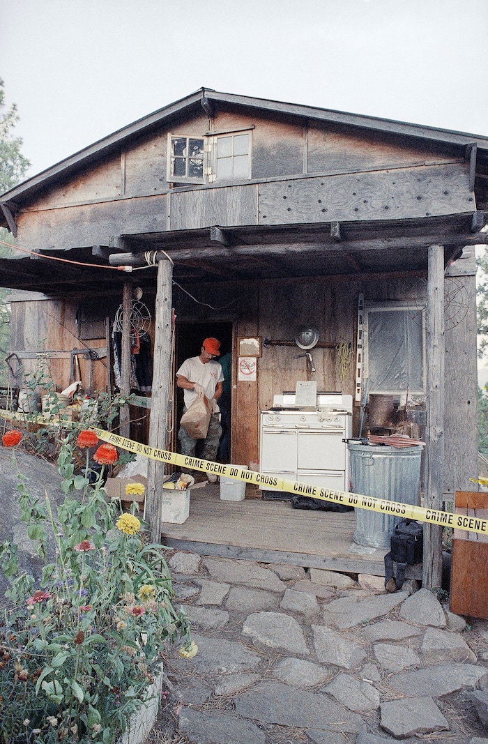 FILE - In this Aug. 31, 1992, file photo, federal agents gather evidence from the home of captured fugitive Randy Weaver near Naples, Idaho. It's been a quarter century since a standoff in the remote mountains of northern Idaho left a 14-year-old boy, his mother and a federal agent dead and sparked the expansion of radical right-wing groups across the country that continues to this day. (AP Photo/Gary Stewart, File)