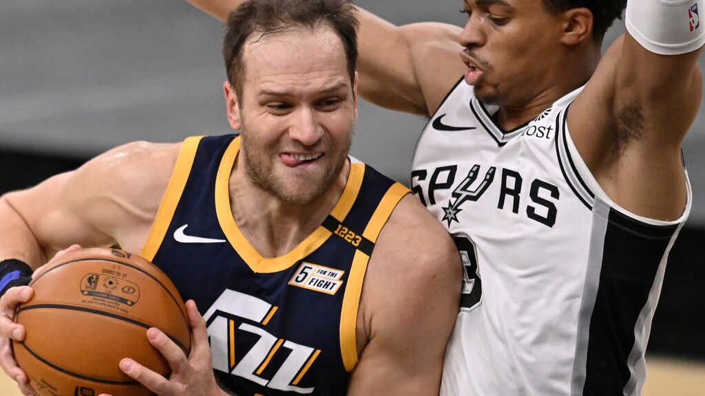 Utah Jazz's Bojan Bogdanovic, left, drives against San Antonio Spurs' Keldon Johnson during the first half of an NBA basketball game, Sunday, Jan. 3, 2021, in San Antonio. (AP Photo/Darren Abate)