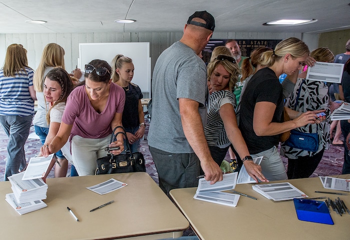 (Leah Hogsten  |  The Salt Lake Tribune) Parents of Uintah Elementary School students fill out reunification forms at the Dee Events Center on the Weber State University campus in Ogden to pick up their children. Evacuees were given food and water as residents waited to hear if they could return to their homes. The Uintah Fire is still burning through the town of Uintah and pockets of South Weber, as well as the unincorporated subdivision of Uintah Highlands.
