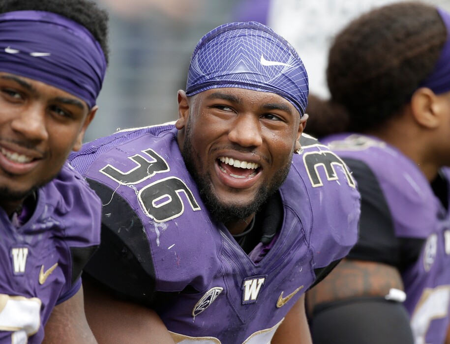 FILE - In this Sept. 3, 2016, file photo, Washington's Azeem Victor smiles on the sidelines during an NCAA college football game against Rutgers, in Seattle. In the midst of being the starting middle linebacker for the No. 4 team in the country, Azeem Victor is trying to do more. Victor’s goals go beyond what he’s doing on the field for Washington and what he’s doing in getting his education. In Victor’s case, doing more means starting a foundation while a college student and football player.  (AP Photo/Elaine Thompson, File)