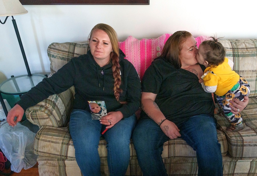 (Leah Hogsten | The Salt Lake Tribune) Angie McEaneney, holds a photo of her newborn son Erik, now 6-months-old next to her sister Felicia Schoenberger, who kisses her daughter Attikiss, 1, as they talk about their pregnancy experiences and births while incarcerated at the Utah State Correctional Facility in 2021. McEaneney had a high-risk pregnancy and Schoenberger's daughter had surgery when she was 10-days-old.
