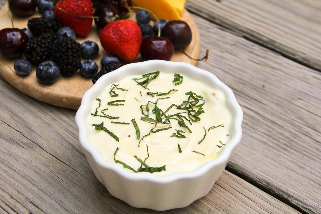 This Aug. 21, 2017 photo shows a tangy orange fruit dip with fresh mint in Bethesda, Md. This dish is from a recipe by Melissa d'Arabian. (Melissa d'Arabian via AP)