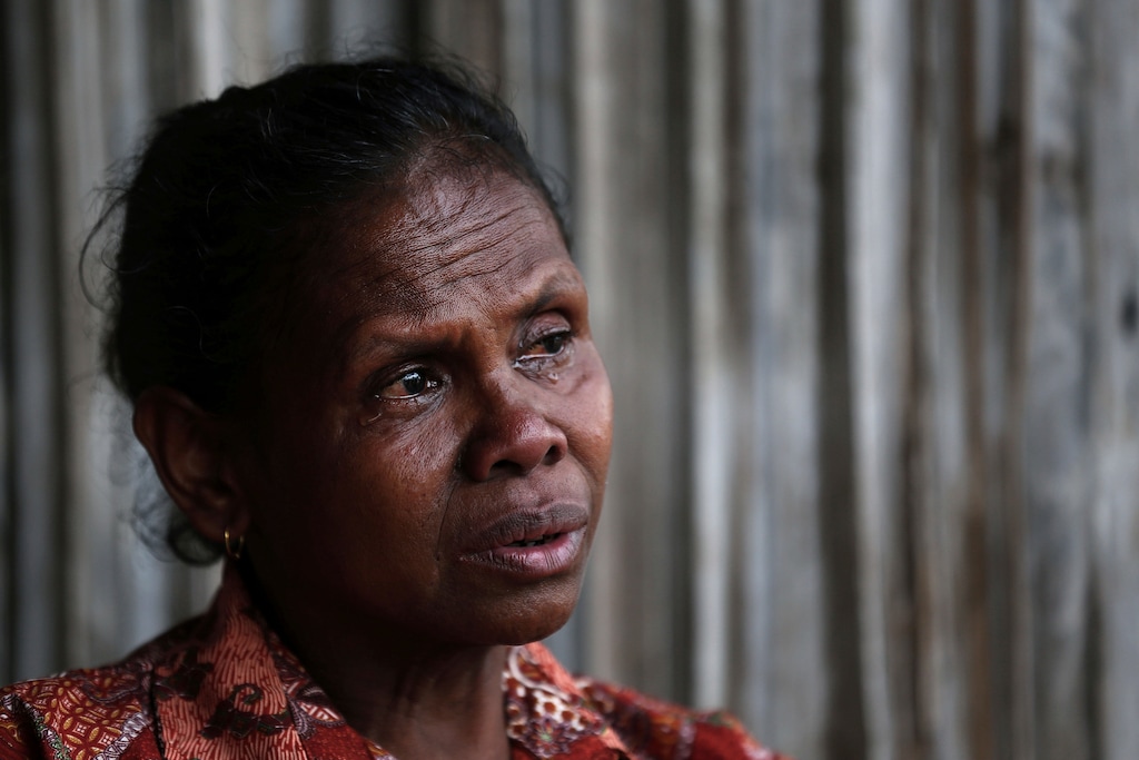 In this Oct. 21, 2018, photo, Yohanna Banunaek, cries as she talks about her late daughter Adelina Sau, in Abi village in West Timor, Indonesia. Sau had been working as a maid for a Malaysian family when a local lawmaker's office received a tip from neighbors who suspected she was being abused. An autopsy determined she died of septicemia and cited possible abuse and neglect. (AP Photo/Tatan Syuflana)
