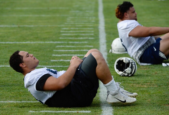 (Francisco Kjolseth  |  The Salt Lake Tribune)  BYU defensive lineman Merrill Tailauli, left and Khyiris Tonga do crunches as their preseason training camp winds down on their practice field Thursday, Aug. 2, 2018.
