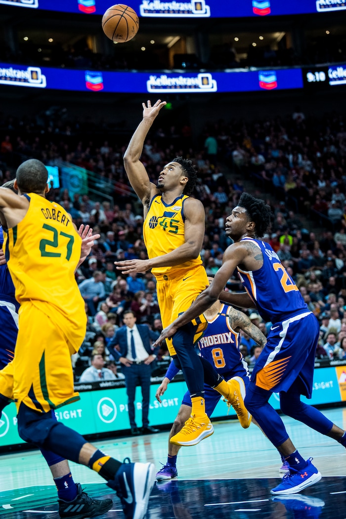 (Chris Detrick  |  The Salt Lake Tribune)  Utah Jazz guard Donovan Mitchell (45) shoots past Phoenix Suns guard Josh Jackson (20) during the game at Vivint Smart Home Arena Thursday, March 15, 2018. Utah Jazz defeated Phoenix Suns 116-88.