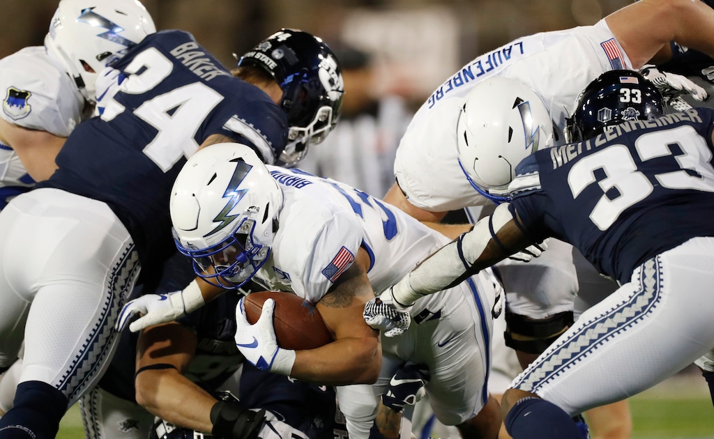 Air Force fullback Taven Birdow, center, is stopped short of the end zone by Utah State defensive end Dalton Baker, left, and linebacker Kevin Meitzenheimer in the first half of an NCAA college football game Saturday, Oct. 26, 2019, at Air Force Academy, Colo. (AP Photo/David Zalubowski)