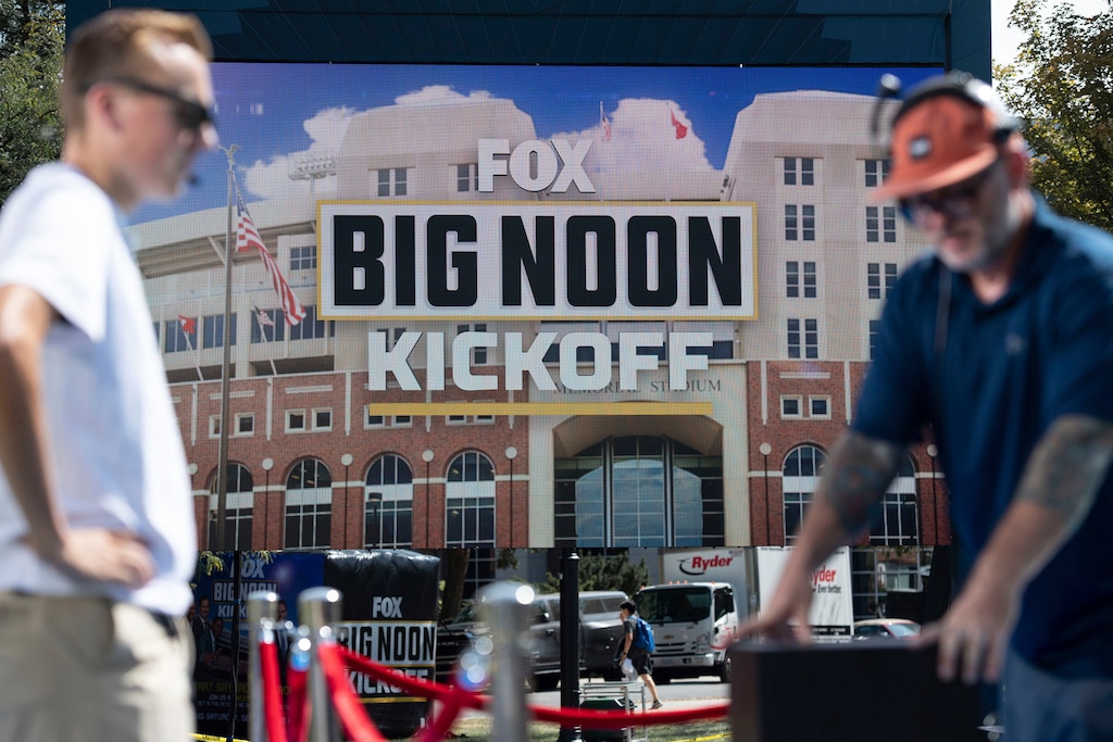 (Noah Riffe | Lincoln Journal Star via AP) Workers, foreground, assemble a set for the Fox "Big Noon Kickoff" football show Sept. 16, 2022, at University of Nebraska Union in Lincoln, Neb. 