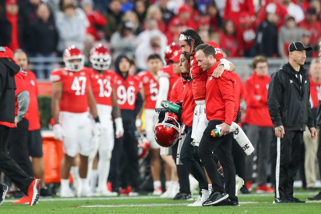 (Meg Oliphant | Special to The Tribune) Utah quarterback Cameron Rising (7) is escorted off the field after an injury in the third quarter against the Penn State Nittany Lions at Rose Bowl Stadium on Jan. 2, 2023 in Pasadena, California.