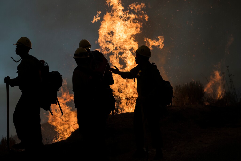 Firefighters monitor a controlled burn along Nacimiento-Fergusson Road to help contain the Dolan Fire near Big Sur, Calif., Friday, Sept. 11, 2020. (AP Photo/Nic Coury)