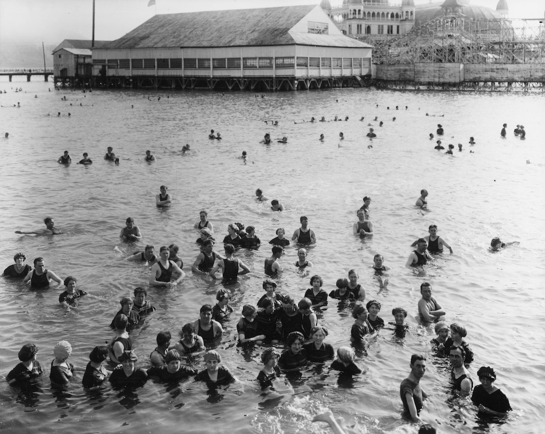 (Utah State Historical Society) Crowds celebrate Independence Day swimming in the Great Salt Lake at the orginial Saltair, July 4, 1913. "A short train ride from downtown Salt Lake City, Saltair offered respite during the hot summer months and provided workers with an affordable source of entertainment in their leisure time. Fifty cents bought visitors a round trip train ticket and admission to the resort," according to the Utah Division of State History.