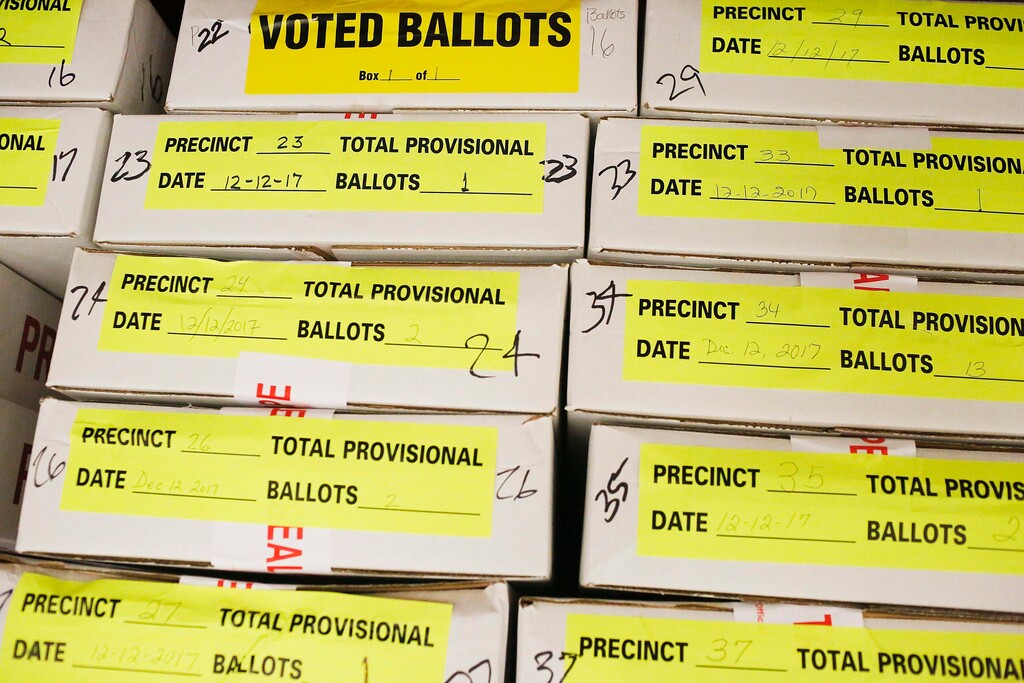 Provisional ballots in boxes are stacked before members of the Shelby County probate office count the voted ballots from last week's U.S. Senate election at the Shelby County court house, Tuesday, Dec. 19, 2017, in Columbiana, Ala. Secretary of State John Merrill says the outcome isn't expected to change. Merrill announced Monday, Dec. 18, 2017, that counties will check write-in votes under a new state law that only requires poll workers to sort through them if the number of write-ins is higher than the winner's margin of victory. There were 22,814 write-ins. (AP Photo/Brynn Anderson)