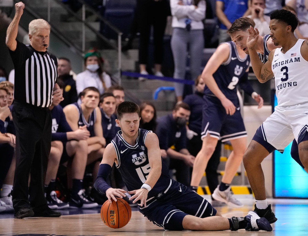 (Francisco Kjolseth | The Salt Lake Tribune) Utah State Aggies guard Rylan Jones (15) is hit in the eye while driving the ball in basketball action between the Brigham Young Cougars and the Utah State Aggies at the Marriott Center in Provo, Wednesday, Dec. 8, 2021.