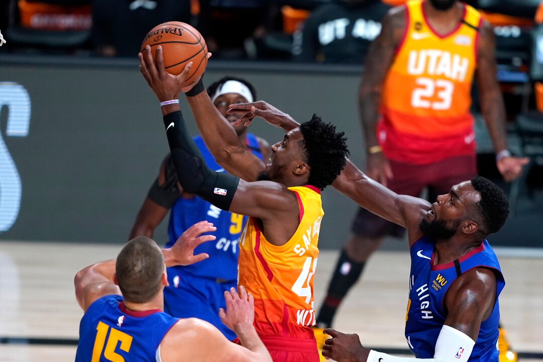 Utah Jazz's Donovan Mitchell (45) goes up for a shot as Denver Nuggets' Paul Millsap (4), right, defends during the first half of an NBA basketball first round playoff game Sunday, Aug. 23, 2020, in Lake Buena Vista, Fla. (AP Photo/Ashley Landis, Pool)