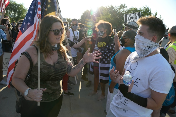 (Francisco Kjolseth  |  The Salt Lake Tribune) Jamie, left, who would only give her first name, with “Patriots Prepared,” talks with Drew Kacey as part of national day of protest against police crimes, the National Alliance Against Racist and Political Repression, the Salt Lake Civilian Police Accountability Council and other groups gather at the Utah Capitol on Saturday, July 18, 2020.