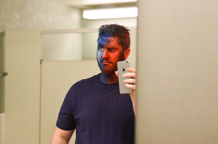 (Francisco Kjolseth | The Salt Lake Tribune) BYU and Utah fan alike Brad Klekas of South Jordan documents the aftermath of getting both colors on his face for a photo shoot in anticipation of the upcoming match up between the two rival teams on Saturday.